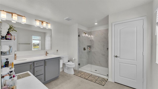 bathroom with tile patterned flooring, toilet, a sink, and a stall shower