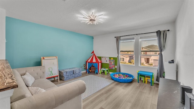 game room featuring wood finished floors and a textured ceiling