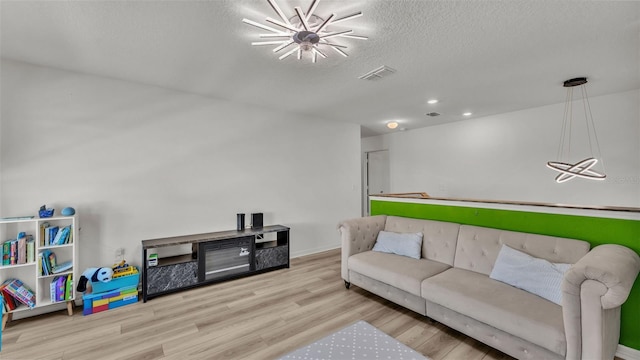living room featuring recessed lighting, wood finished floors, visible vents, and a textured ceiling