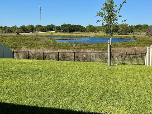 view of yard featuring a water view and fence