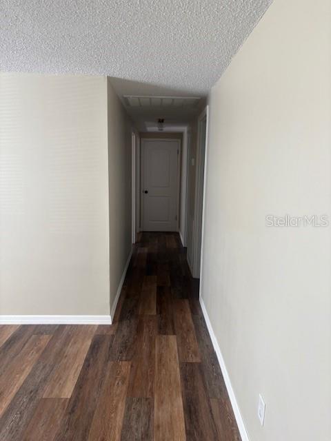 4830 Melody Ln, Lakeland, FL 33805 - hallway featuring visible vents, baseboards, a textured ceiling, and wood finished floors