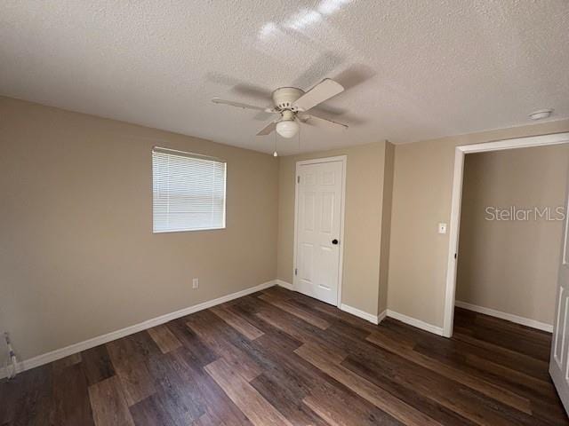4830 Melody Ln, Lakeland, FL 33805 - unfurnished bedroom featuring a textured ceiling, baseboards, and dark wood finished floors