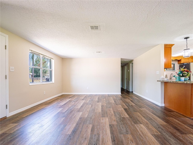 4830 Melody Ln, Lakeland, FL 33805 - unfurnished living room with dark wood-type flooring, a textured ceiling, and visible vents