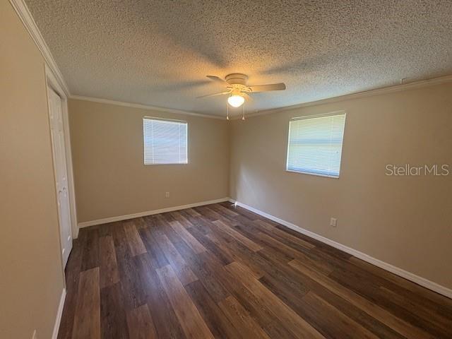 4830 Melody Ln, Lakeland, FL 33805 - unfurnished room with dark wood-type flooring, ornamental molding, ceiling fan, and a textured ceiling