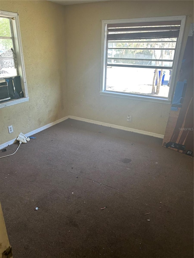unfurnished room with carpet flooring and baseboards