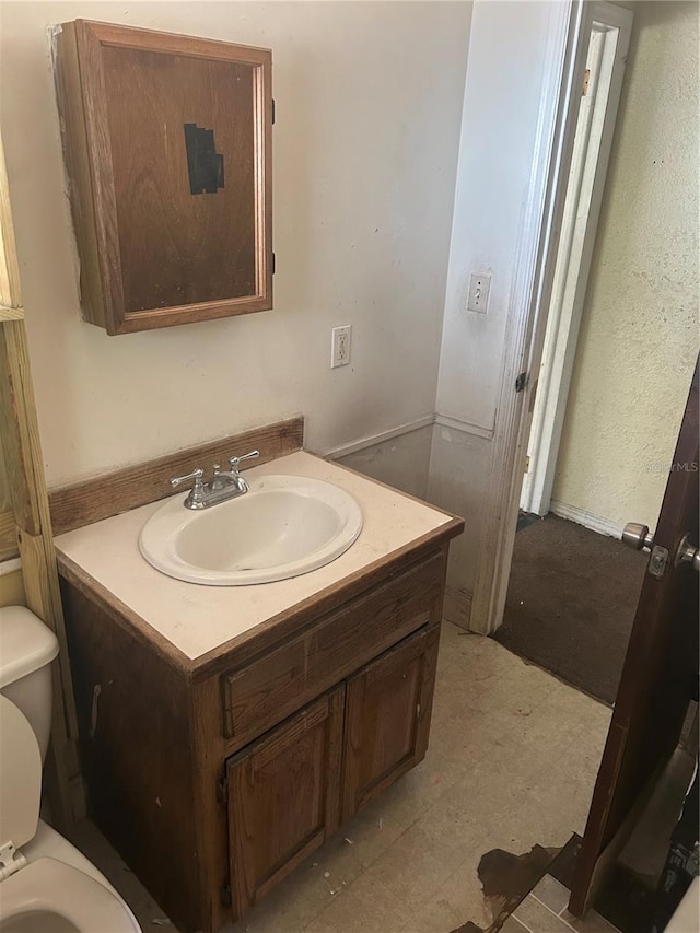 half bath with vanity, toilet, and tile patterned floors