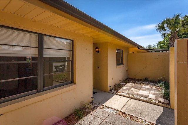 view of home's exterior with stucco siding and fence