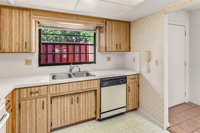 kitchen featuring white dishwasher, a sink, wallpapered walls, and light countertops