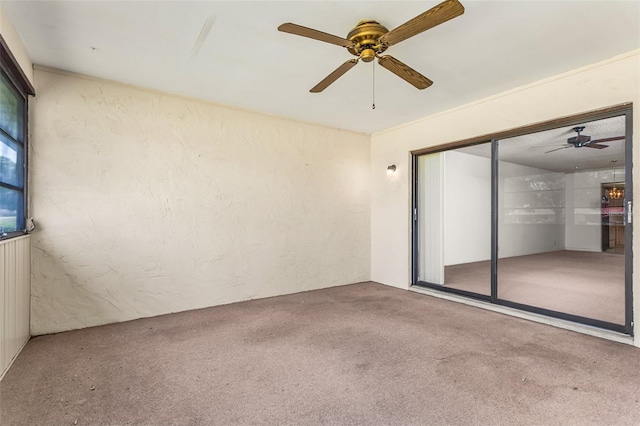 carpeted spare room with a ceiling fan
