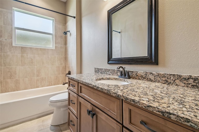 bathroom with toilet, a textured wall, vanity, and shower / bathing tub combination