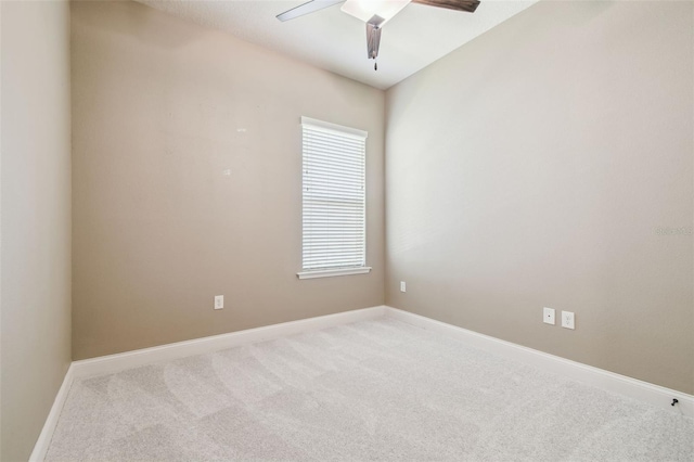 carpeted empty room with ceiling fan and baseboards