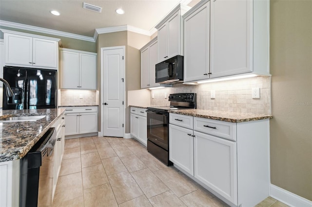 kitchen with stone counters, visible vents, decorative backsplash, crown molding, and black appliances