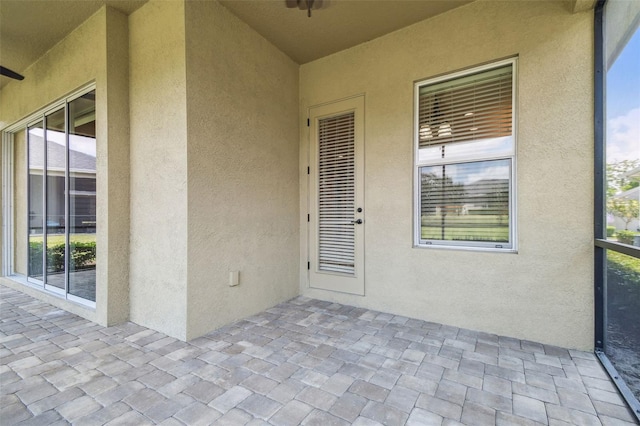 view of exterior entry featuring a patio and stucco siding