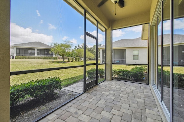 unfurnished sunroom with a ceiling fan
