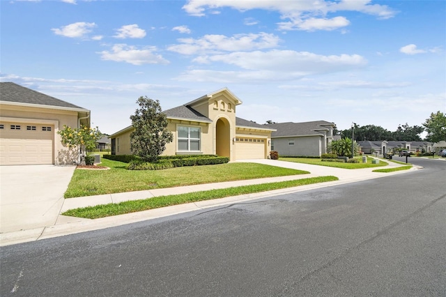 mediterranean / spanish-style house with stucco siding, an attached garage, a front lawn, and concrete driveway