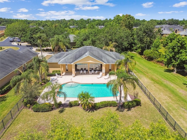 pool featuring a yard, a patio area, and a fenced backyard