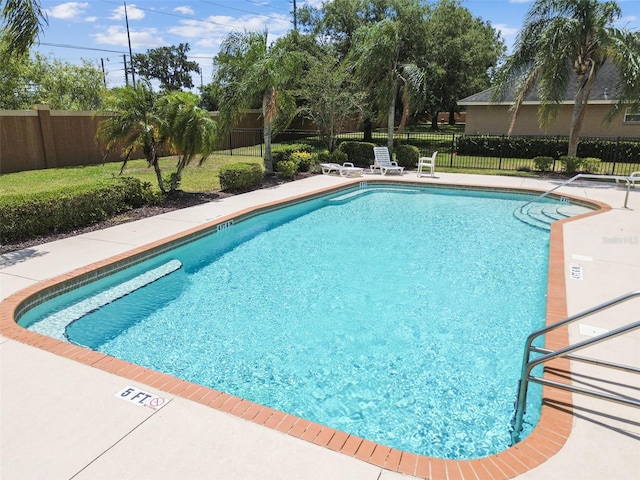 community pool featuring a fenced backyard and a patio area