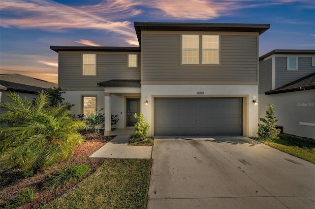 traditional-style home featuring concrete driveway, stucco siding, and a garage