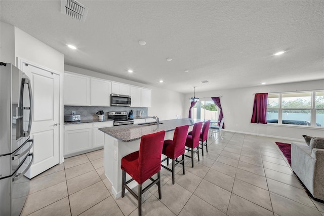 kitchen with a sink, light tile patterned floors, stainless steel appliances, visible vents, and recessed lighting