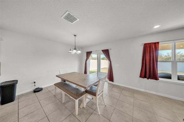 dining area with baseboards, an inviting chandelier, visible vents, and light tile patterned floors