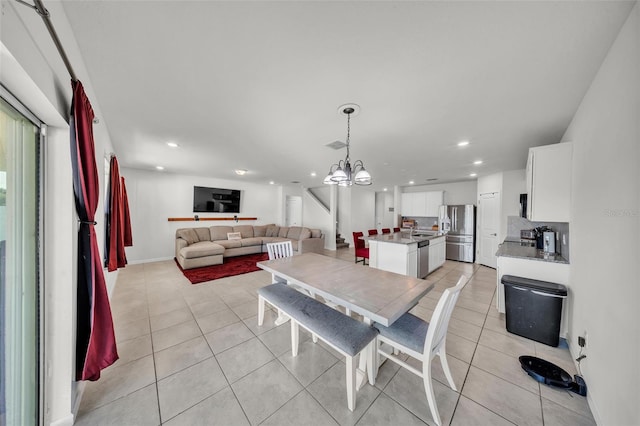 dining area featuring recessed lighting, light tile patterned floors, and an inviting chandelier
