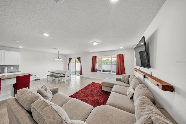 living room featuring recessed lighting, light tile patterned floors, baseboards, a textured ceiling, and a notable chandelier