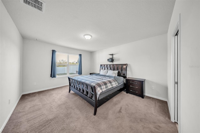 bedroom with visible vents, baseboards, carpet flooring, and a textured ceiling