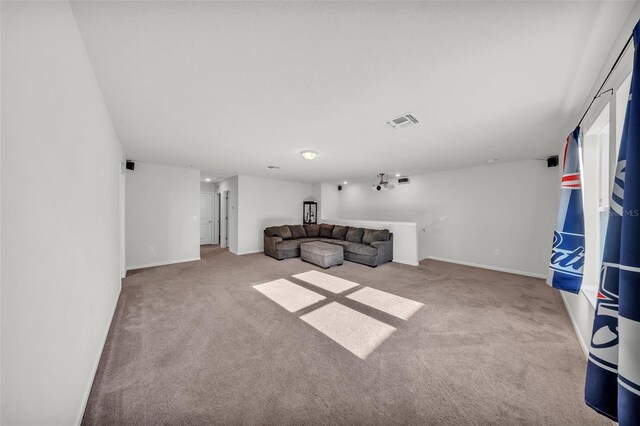 unfurnished living room with carpet, visible vents, and baseboards
