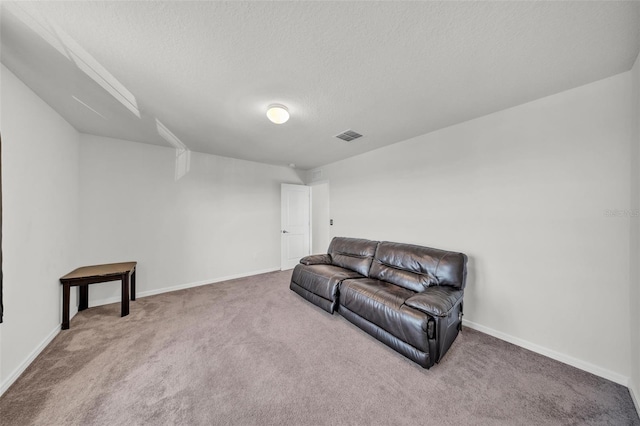 living area with baseboards, visible vents, a textured ceiling, and carpet flooring