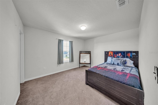 carpeted bedroom with baseboards, a textured ceiling, and visible vents