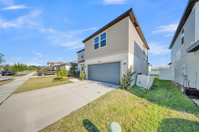 view of front facade with fence, a front lawn, driveway, and a garage