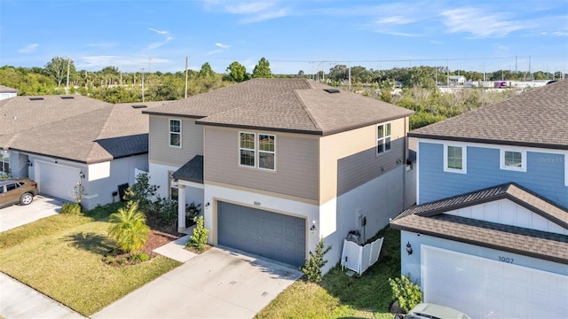 traditional home with an attached garage, a shingled roof, driveway, and stucco siding