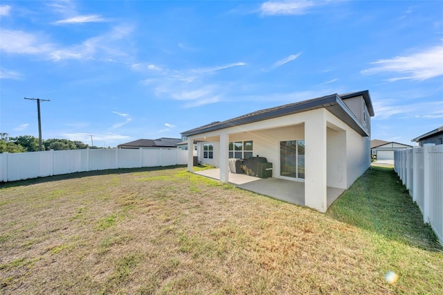 back of house with a patio area, a fenced backyard, a yard, and stucco siding