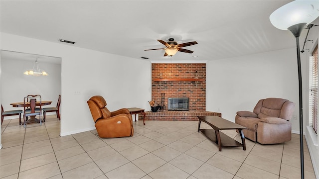 living room with ceiling fan with notable chandelier, visible vents, a fireplace, and light tile patterned floors
