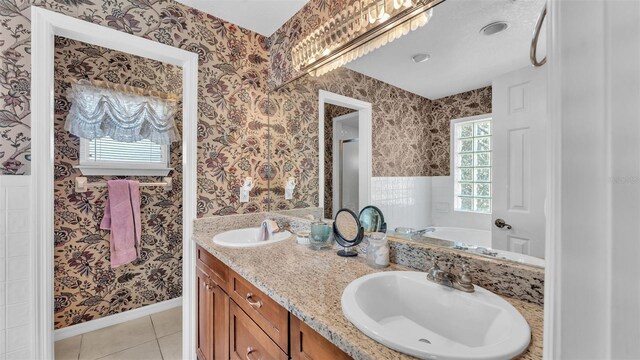 bathroom with wallpapered walls, tile patterned flooring, and a sink