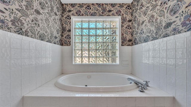 bathroom featuring wallpapered walls and a bath