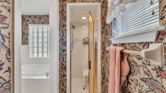 full bathroom with wallpapered walls, a whirlpool tub, and a stall shower