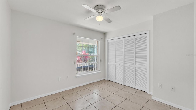 unfurnished bedroom with baseboards, a closet, and light tile patterned flooring