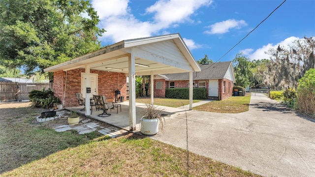 view of patio featuring driveway, a carport, and fence