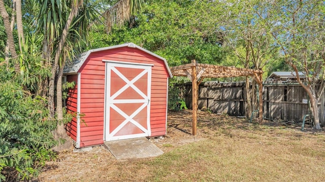 view of shed with a fenced backyard and a pergola