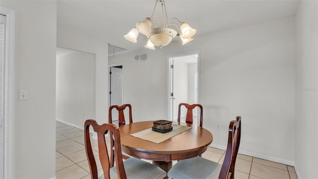 dining room with baseboards, a notable chandelier, and light tile patterned floors