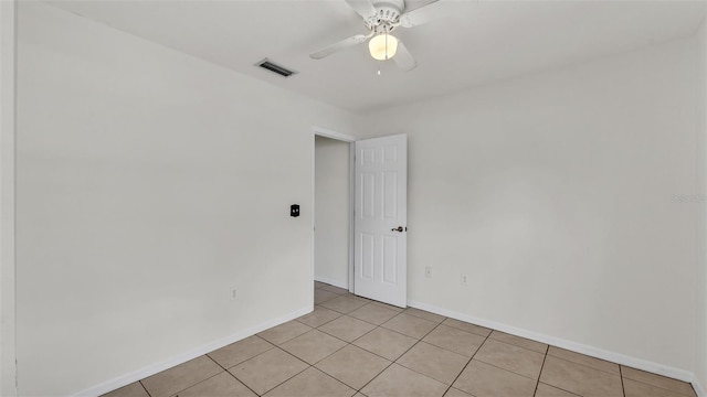 empty room with visible vents, baseboards, ceiling fan, and light tile patterned floors