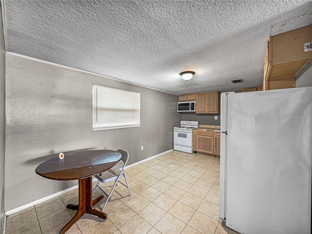 1720 Kendrick Ln, Lakeland, FL 33805 - kitchen with baseboards, light tile patterned floors, white appliances, and brown cabinets