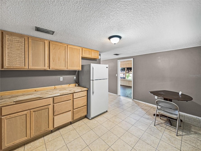 1720 Kendrick Ln, Lakeland, FL 33805 - kitchen with visible vents, a textured ceiling, butcher block countertops, and freestanding refrigerator