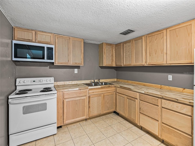 1720 Kendrick Ln, Lakeland, FL 33805 - kitchen featuring stainless steel microwave, light brown cabinetry, white range with electric cooktop, a sink, and visible vents