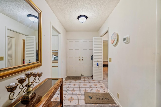 foyer featuring a textured ceiling and baseboards