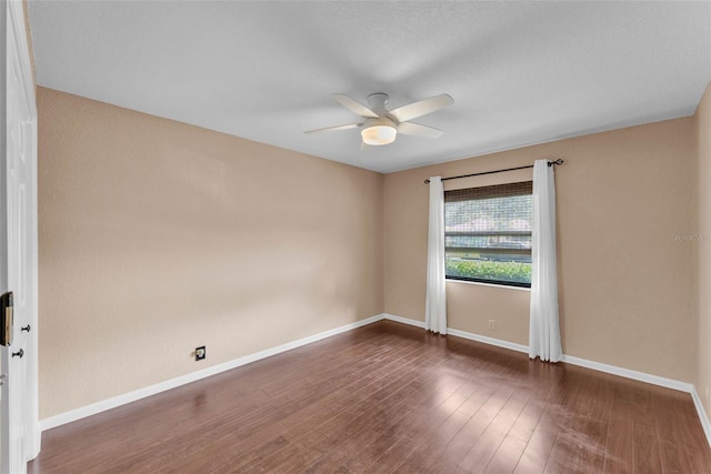 unfurnished room featuring baseboards, a ceiling fan, and wood finished floors