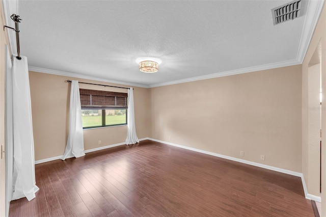 spare room featuring visible vents, ornamental molding, baseboards, dark wood-style floors, and a textured ceiling
