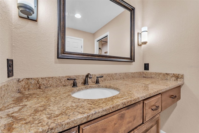 bathroom with vanity and a textured wall