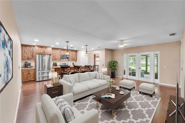 living area featuring visible vents, recessed lighting, baseboards, and wood finished floors